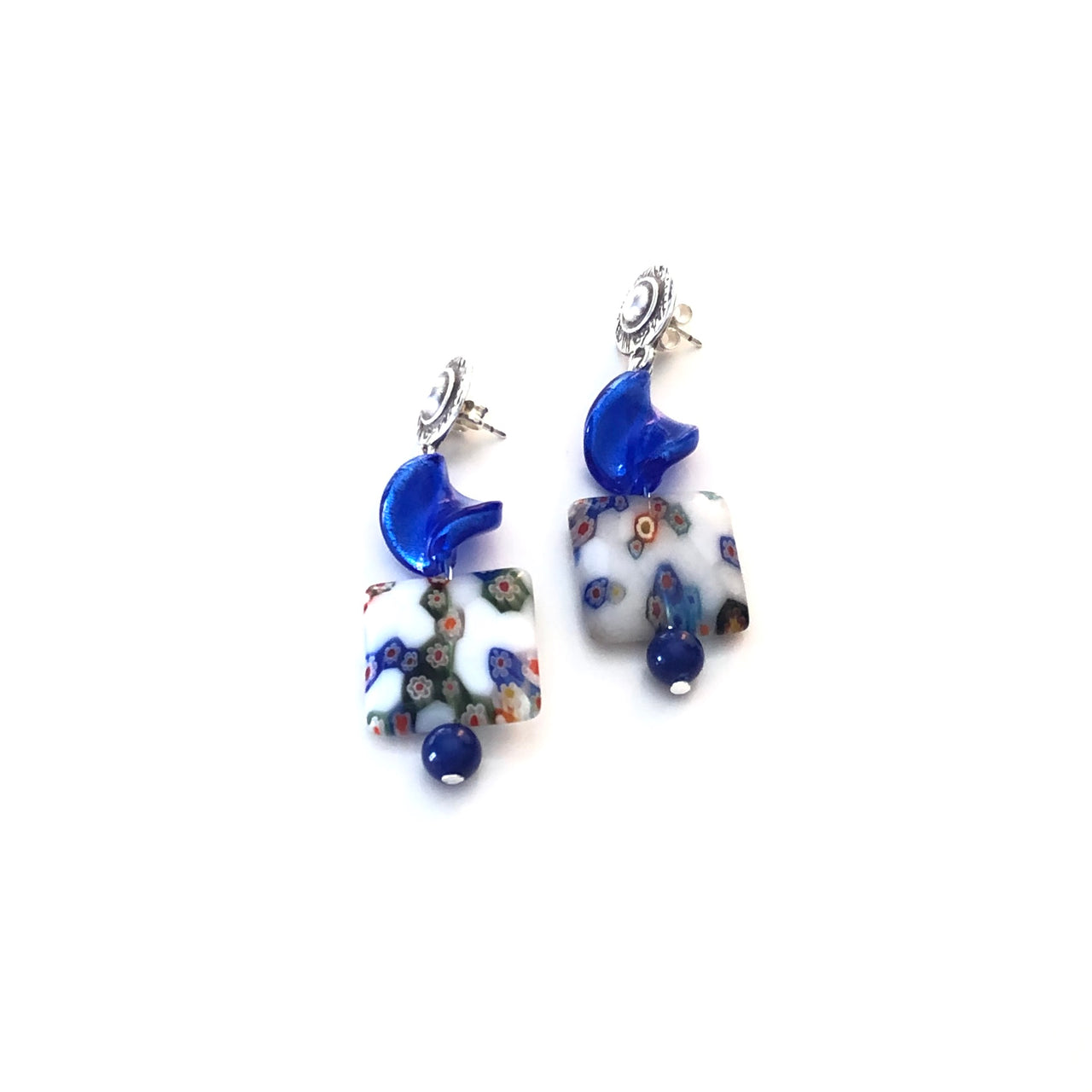 Pendientes martillados de Zamak con baño de plata, con un twist de cristal azul y unos cristales cuadrados blancos y azules y una cuenta de ágata azul, hacen de esta pieza una obra de arte. Estos pendientes son simplemente ideales para cualquier estilo. Combínalo como quieras.